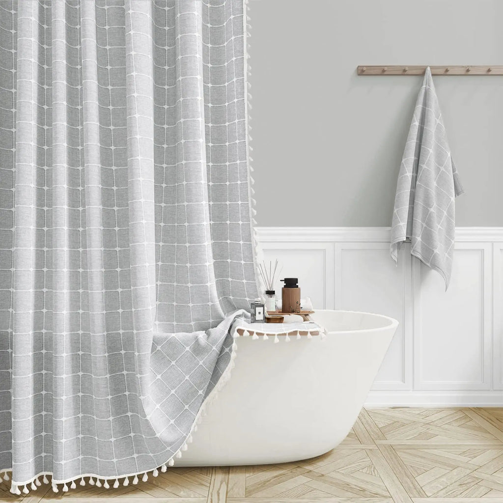 Bathroom with a white bathtub, dark grey grid-patterned shower curtain, and towel.