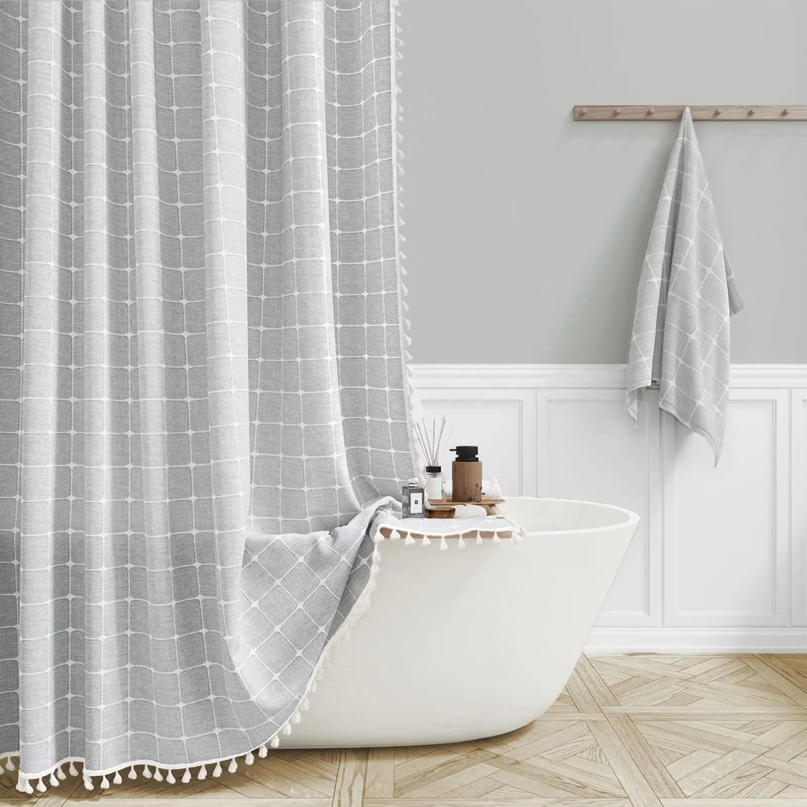 Bathroom with a white bathtub, dark grey grid-patterned shower curtain, and towel.