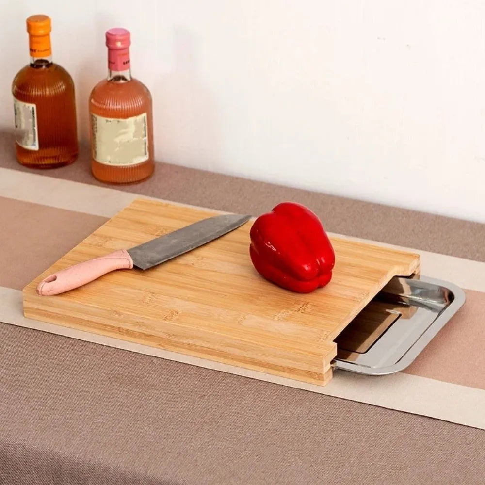 Beech wood cutting board with knife and red pepper on a countertop, with two bottles in the background.