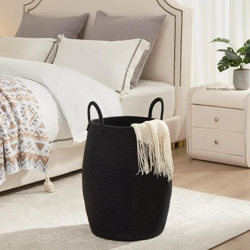 Black Boho Cotton Rope Storage Basket with a white blanket in a bedroom setting