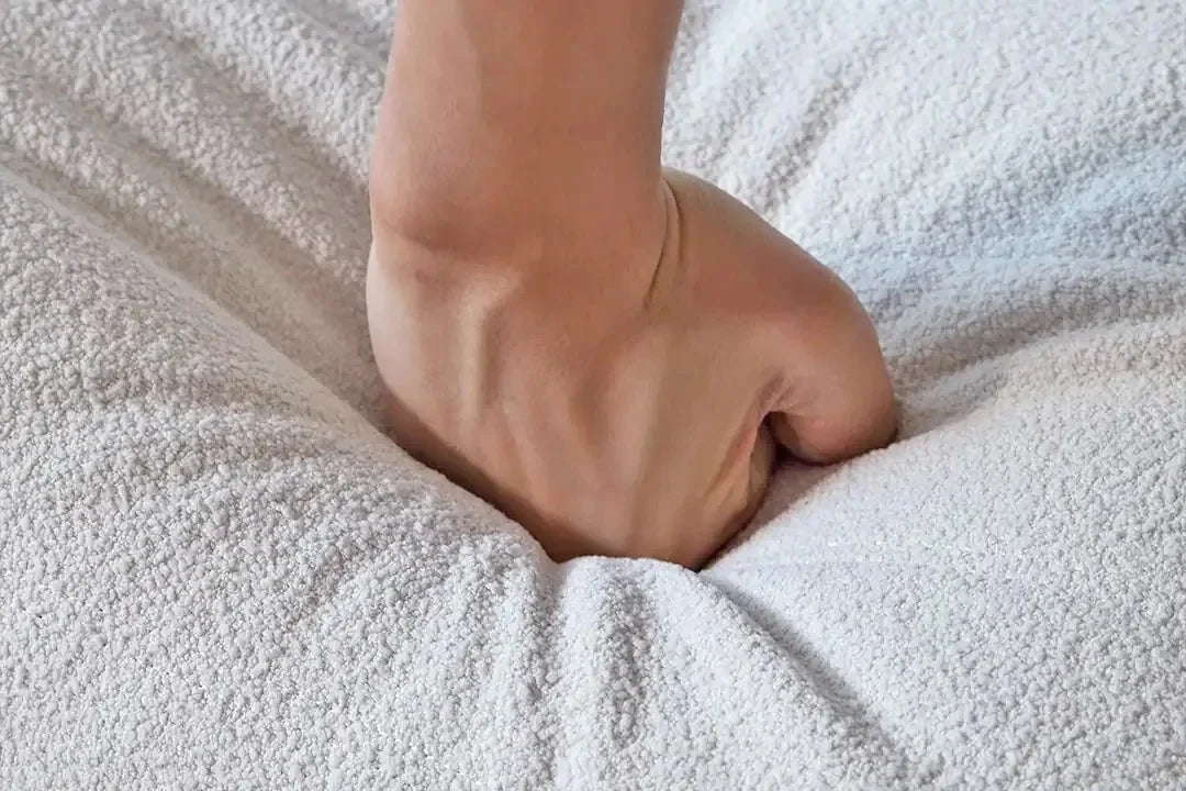 Close-up of a hand resting on a textured beige surface