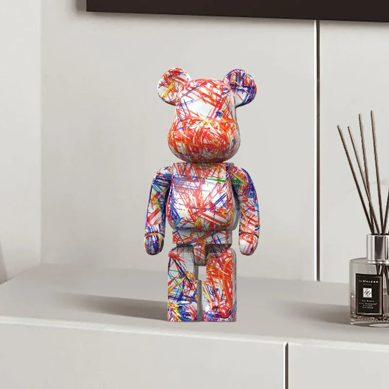 Colorful graffiti bear-shaped figurine on a white surface with a diffuser in the background
