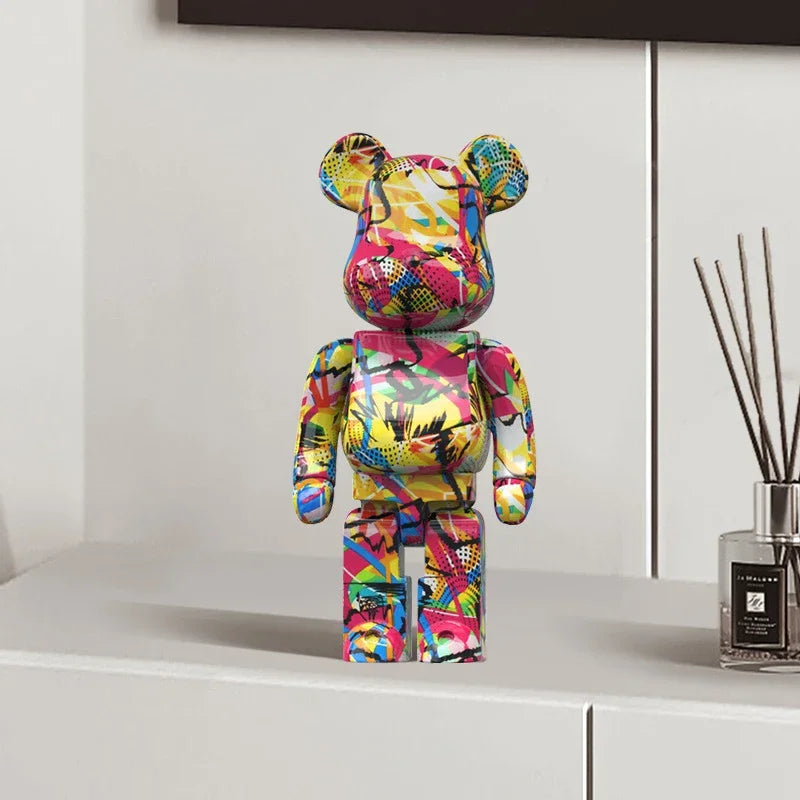 Colorful graffiti bear figurine on a white countertop surface with a diffuser in the background