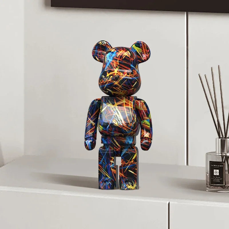 Colorful graffiti bear figurine on a white surface with a diffuser in the background