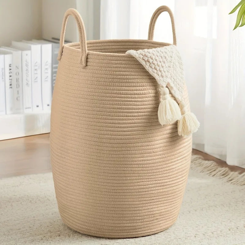 Khaki Boho Cotton Rope Storage Basket with a white tassel on a light wooden floor.