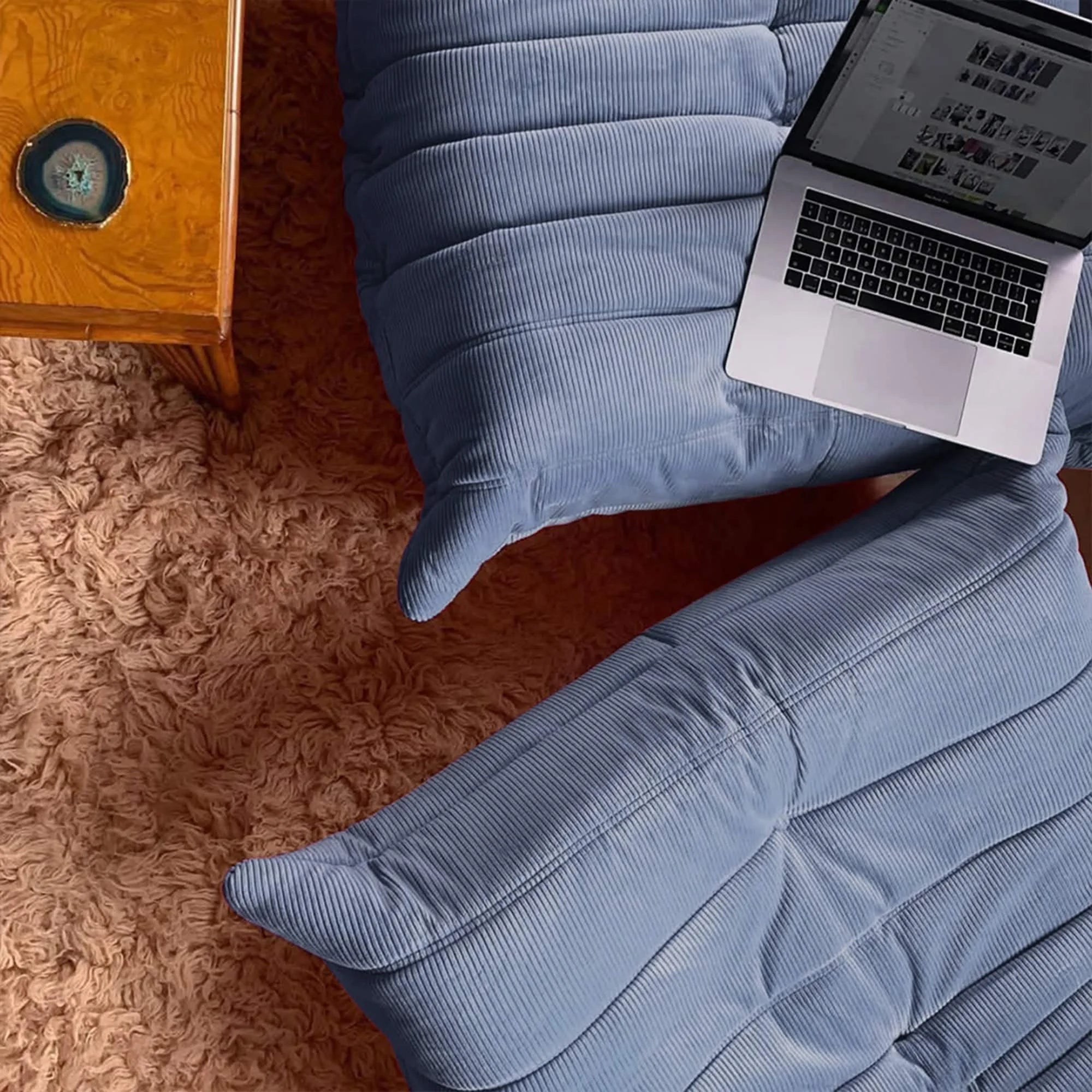 Laptop on a Blue Corduroy Caterpillar Lazy Sofa with a wooden side table in the background