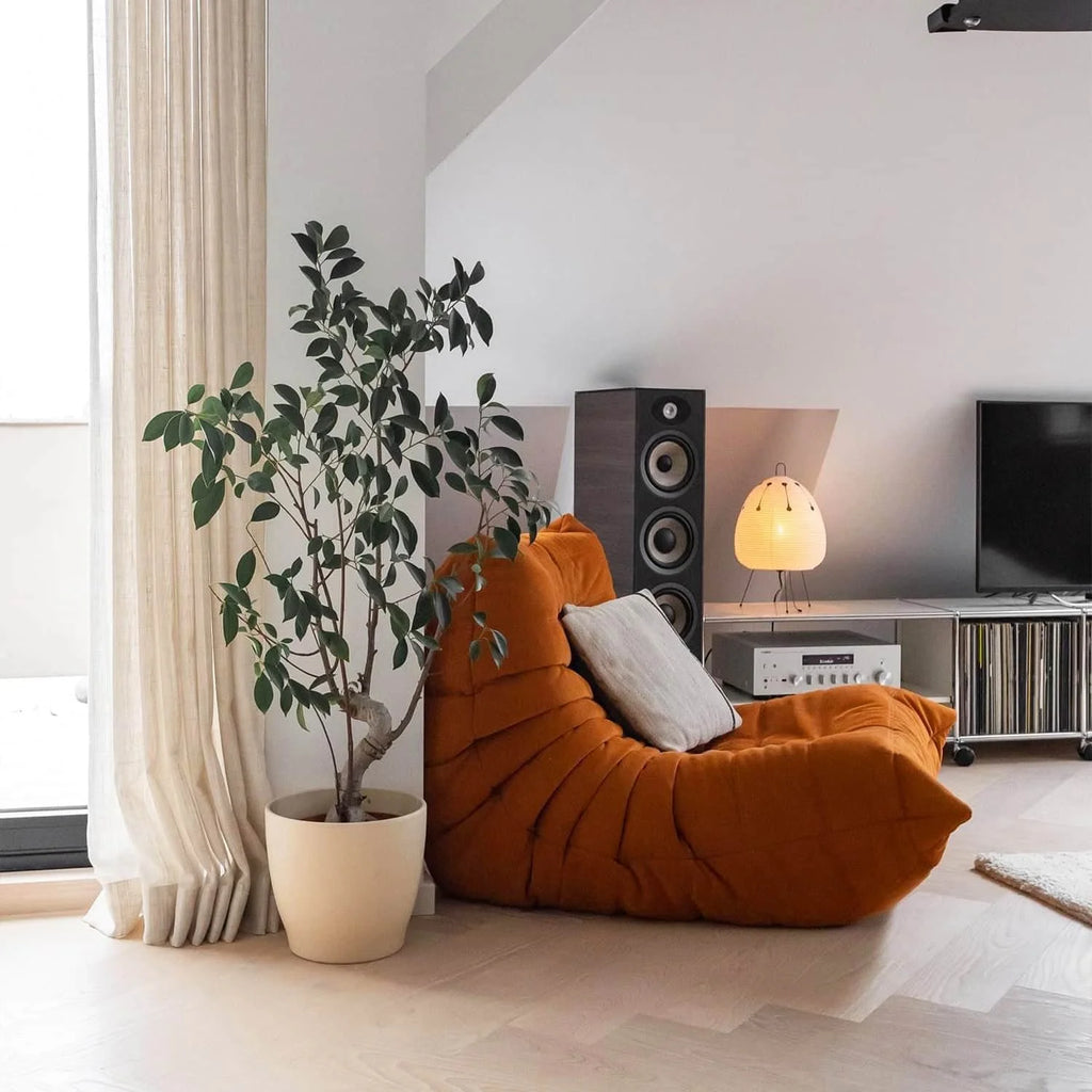 Modern living room with a one seater Orange Corduroy Caterpillar Lazy Sofa, plant, and entertainment setup.