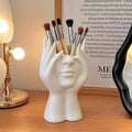 Nordic Human Body Sculpture Desk Organizer with makeup brushes on a wooden surface.