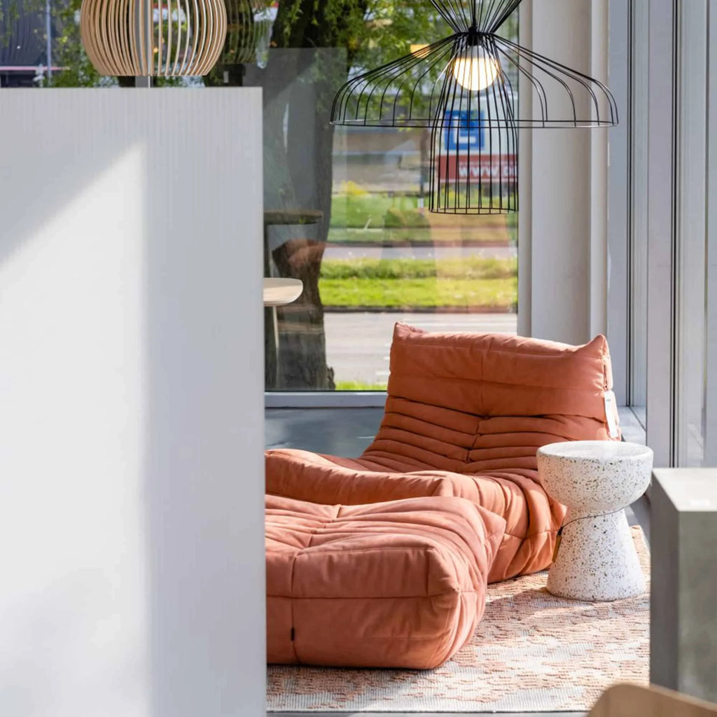 Orange Caterpillar Lazy Sofa in a modern indoor setting with a window view and cushion.