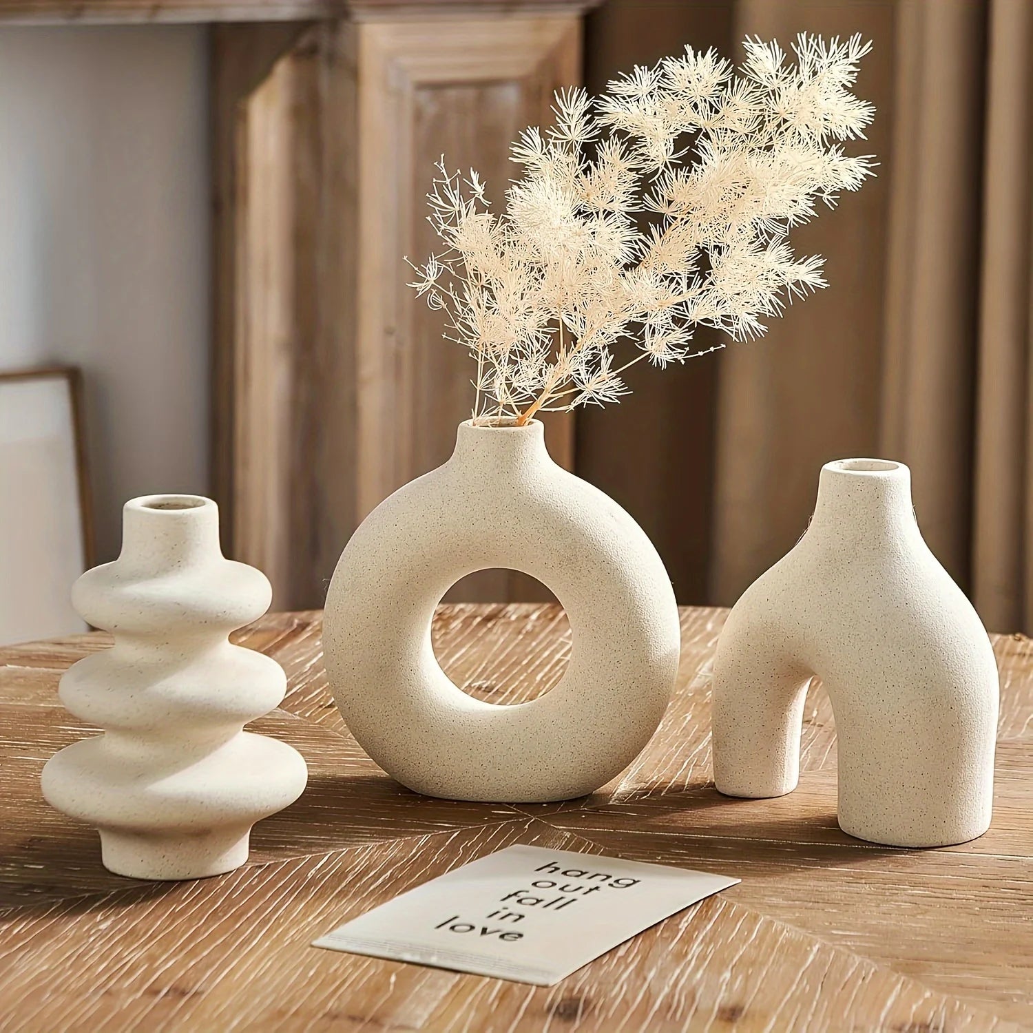 Three light yellow Boho Ceramic Vases on a wooden surface with a neutral background