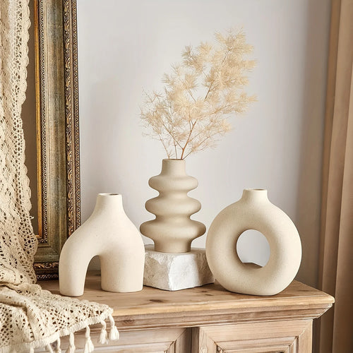 Three light yellow decorative Boho Ceramic Vases on a wooden surface with a neutral background