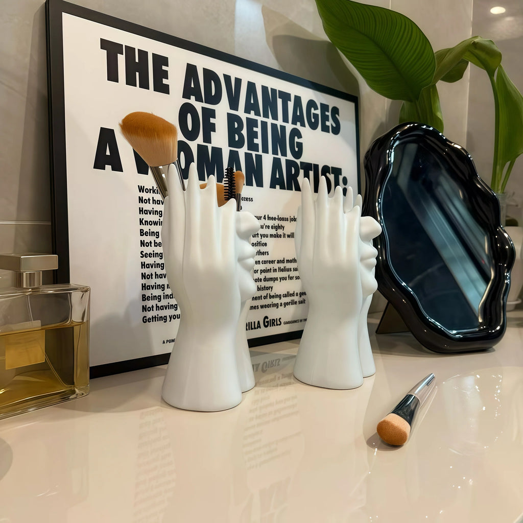 Two Nordic Human Body Sculpture Desk Organizers with makeup brushes in a holder with a framed quote on a shelf.