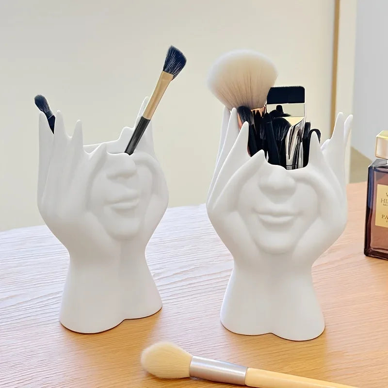 Two white Nordic Human Body Sculpture Desk Organizers with makeup brushes on a vanity table.