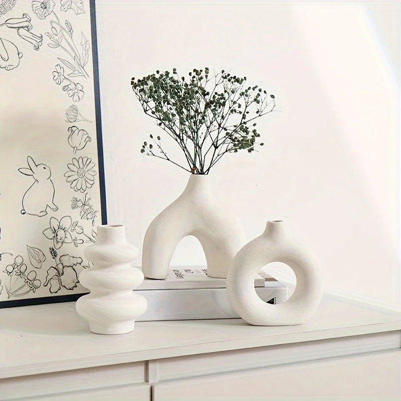 White Boho Ceramic Vases on a white surface with a framed artwork in the background