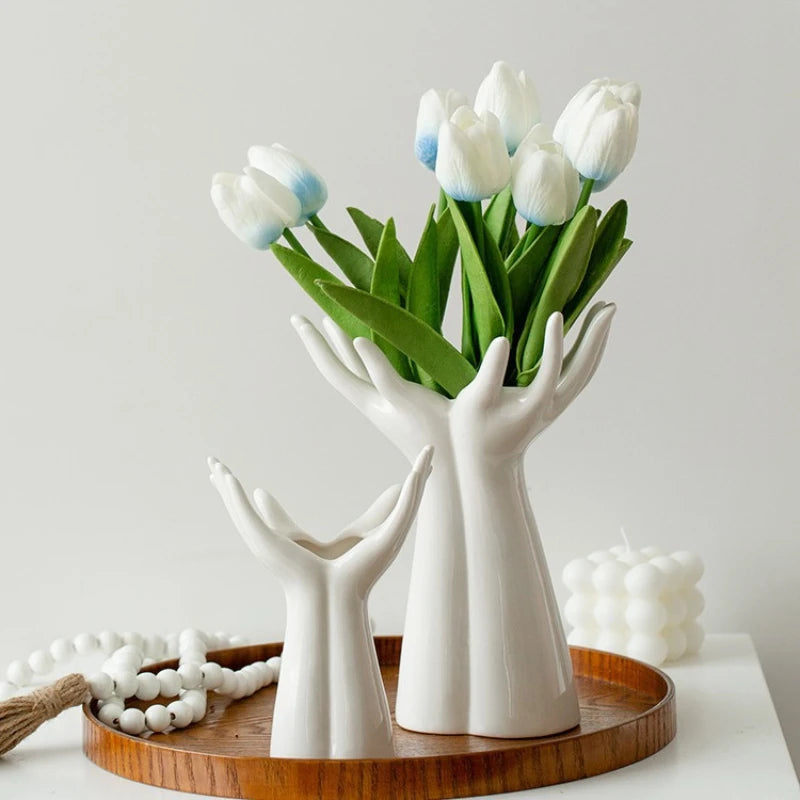 White Ceramic Hand Palm Vases hands holding a bouquet of white tulips on a wooden tray with a white background