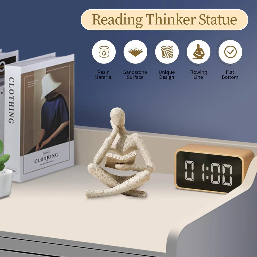 White Thinker Reading Sculpture on a desk with a digital clock and books in the background.
